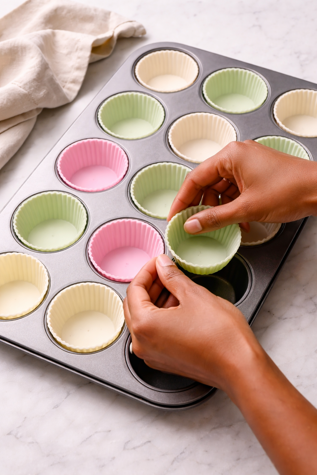 Preparing silicone cups in a muffin tin for strawberry matcha freezer cups