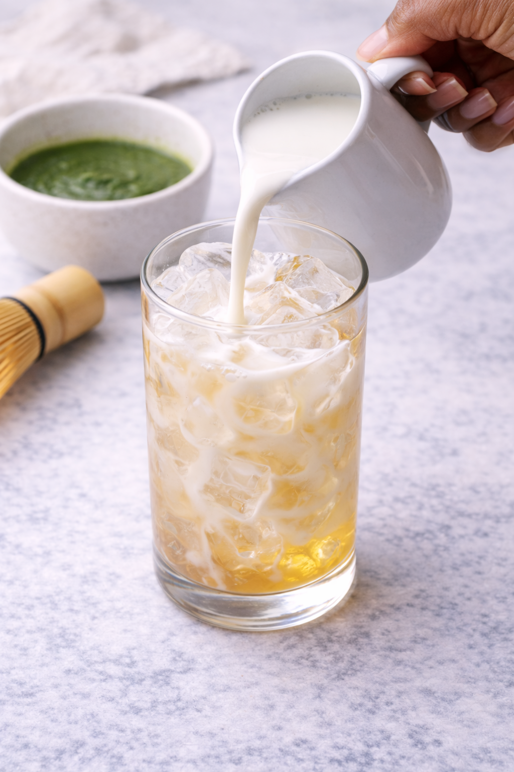 Step 4: Pouring milk over ice for an iced matcha latte