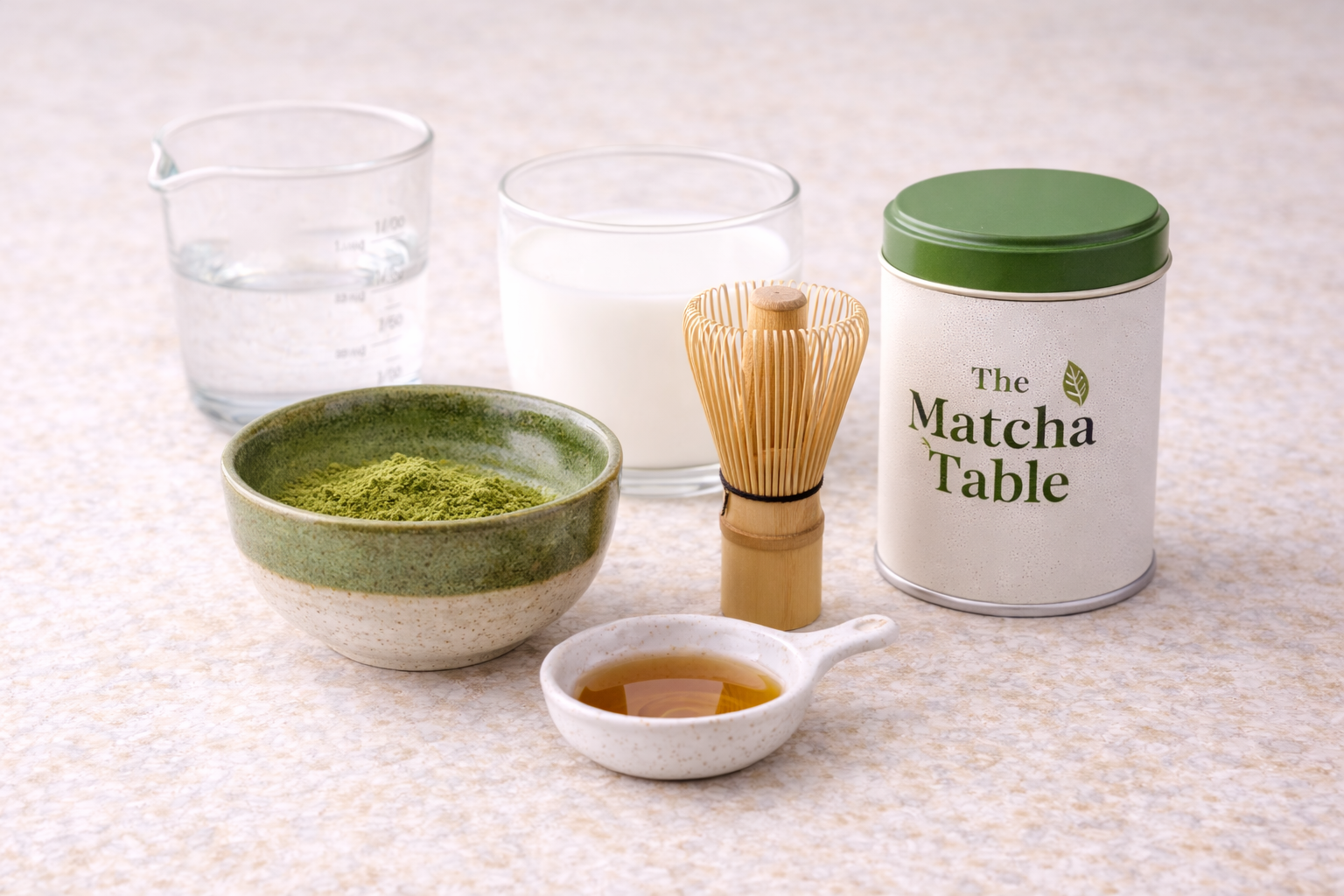 Ingredients for a homemade matcha latte including matcha powder, milk, hot water, and sweetener
